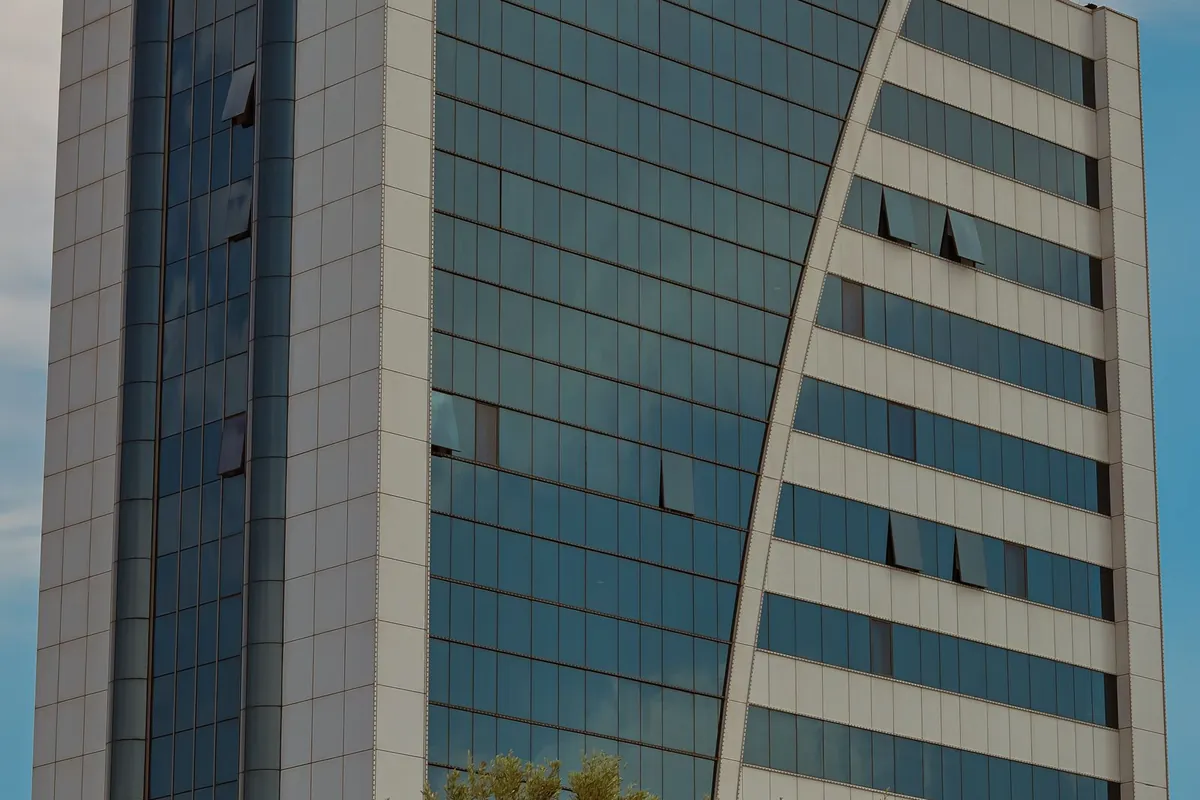 Modern office building with a glazed facade against a blue sky