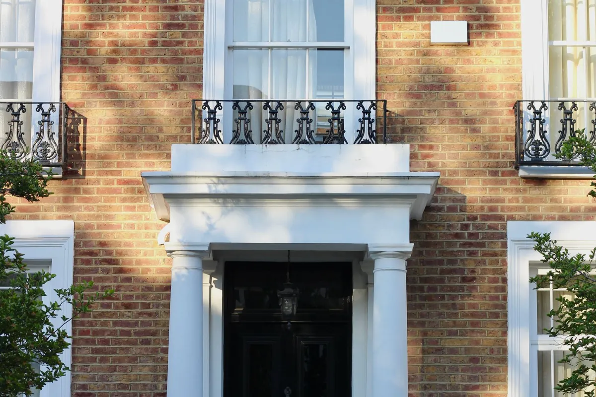 Brick townhouse with white sash windows and a black front door